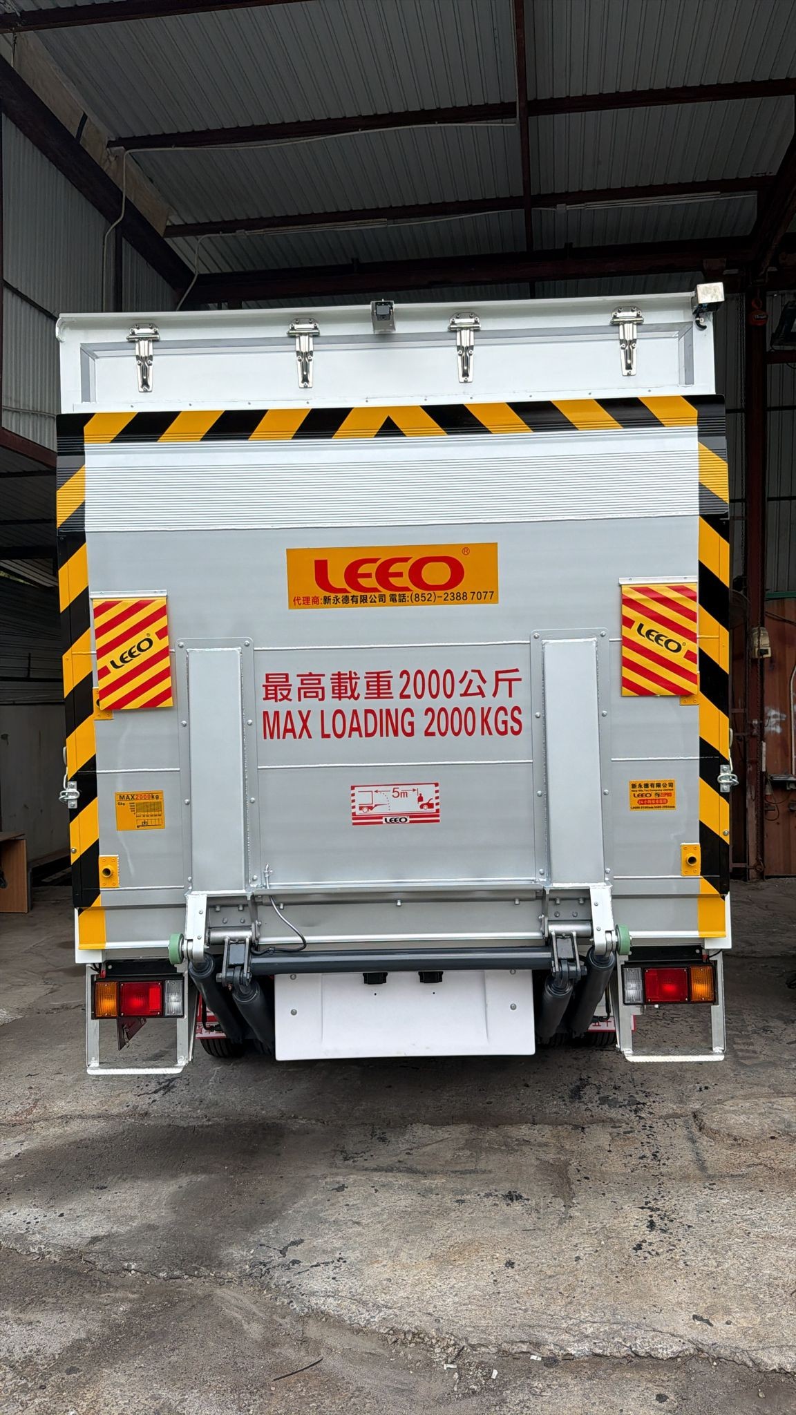 LA-20-135 aluminium tail lift with safety load sticker and yellow-black warning stripes